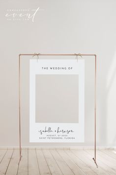 a wedding sign hanging on a metal frame in an empty room with wood flooring