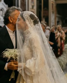 an older man and woman standing next to each other in front of a wedding ceremony