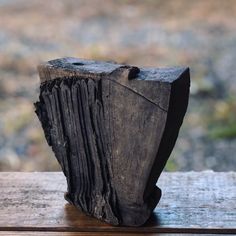 a piece of wood sitting on top of a wooden table next to a glass window