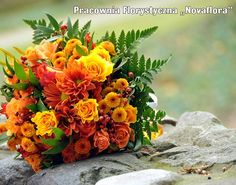 a bouquet of flowers sitting on top of a rock