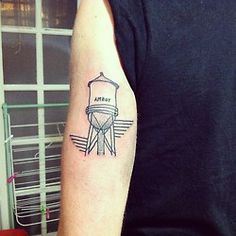 a man's arm with a small tattoo of a water tower on the side