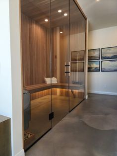 a glass walled sauna in the corner of a room