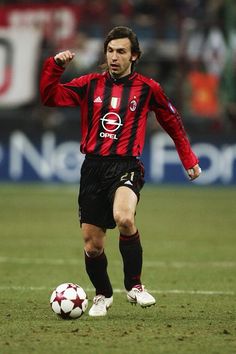 a man kicking a soccer ball on top of a field