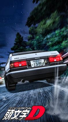 the back end of a white car driving down a street at night with trees in the background