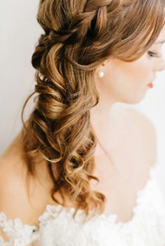 a woman with long hair wearing a wedding dress and braided in to her hair