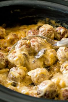 a crock pot filled with meatballs and cheese