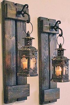 two lanterns are hanging on the wall next to each other, one is lit up