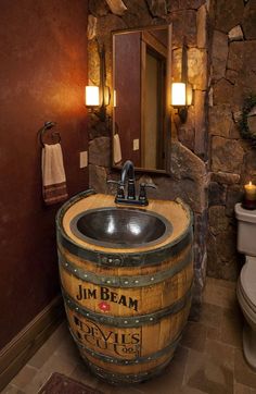 a bathroom with a sink, toilet and stone wall in it's own area