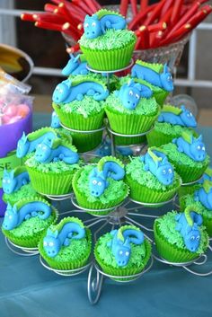 cupcakes are arranged in the shape of a tree on a blue tablecloth