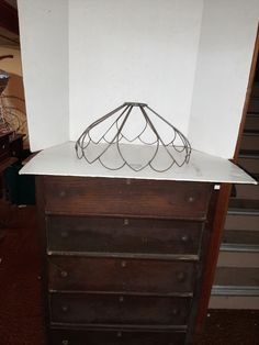 a wooden dresser with a metal object on top