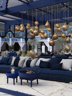 a living room filled with blue couches and lots of gold balls hanging from the ceiling