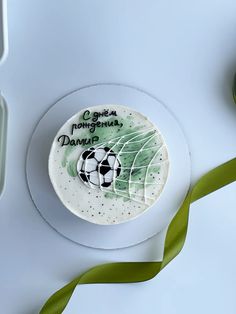 there is a cake with a soccer ball on it next to some green ribbons and scissors