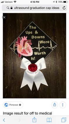 a graduation cap with the words ups & downs were worth on it and a red rose