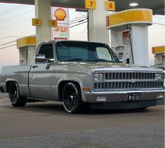 a silver truck parked in front of a gas station