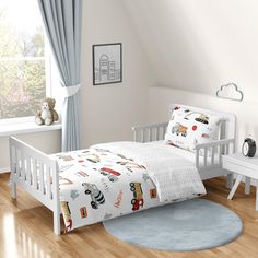 a child's bed with cars and trucks on it in a white room next to a window