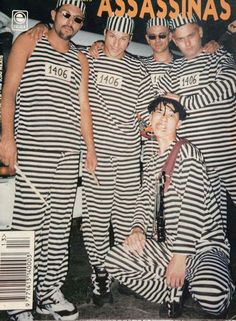 a group of men dressed in jail clothes posing for a photo with one man wearing sunglasses