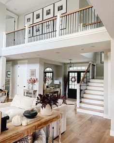 a living room filled with furniture and a staircase leading up to the second story area