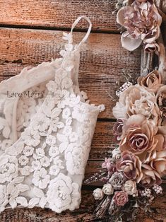 two wedding garters with flowers on them sitting next to an old wooden table