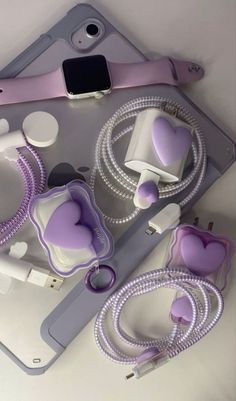 purple and white items are arranged on a table with an apple phone in the background