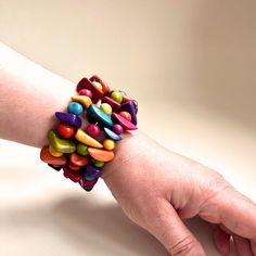 a person's hand with a bracelet made out of colorful candy beads on it