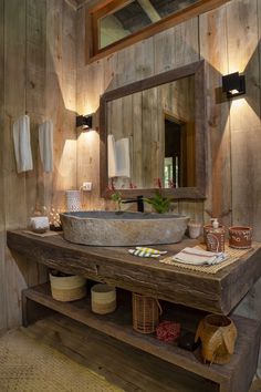 a rustic bathroom with wooden walls and wood flooring, including a large mirror above the sink