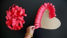 someone is making a heart out of paper