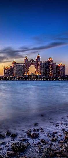 the palace hotel and casino is lit up at night on the water's edge