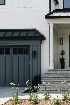 a house with steps leading up to the front door and flowers growing on the side