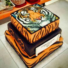 there is a cake that looks like a tiger on top of some other cakes in the background