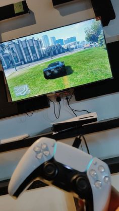 a person holding a video game controller in front of a flat screen tv