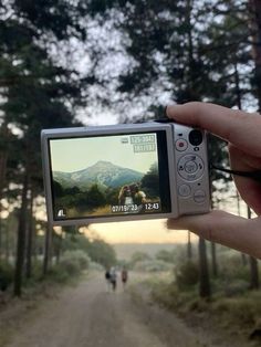 someone is holding up their camera to take a photo on the road in front of them