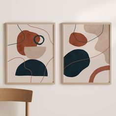 two abstract paintings hang on the wall next to a chair