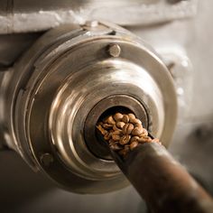 a metal object with nuts in it on the side of a machine that is spinning