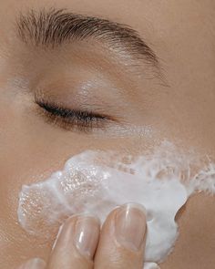 a close up of a person shaving their face with cotton swabs on it