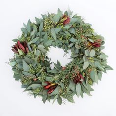 a wreath with green leaves and red berries