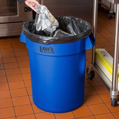 a blue trash can sitting on top of a kitchen floor