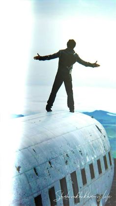 a man standing on top of an airplane with his arms spread out and hands outstretched