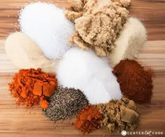 several different types of spices on a wooden surface