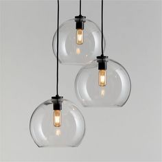 three clear glass globe lights hanging from black cords