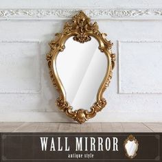 a mirror sitting on top of a wooden floor next to a white brick wall with the words wall mirror written below it