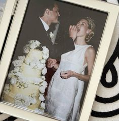 a man and woman standing next to each other in front of a cake