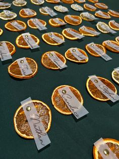 orange slices with price tags on them sitting on a green tablecloth covered in gold foil