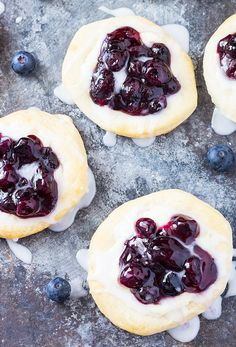 four blueberry shortbreads with icing and fresh berries