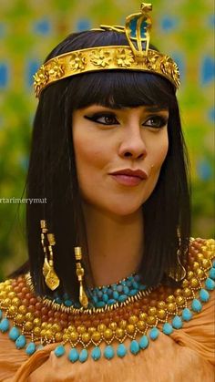 an egyptian woman with long black hair and gold jewelry