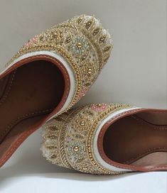 Introducing our exquisite handcrafted ladies Cream & Beige khussa jutti, a blend of elegance and tradition designed to adorn your feet with timeless beauty. Crafted with meticulous attention to detail, this stunning khussa features a captivating Grey hue embellished with a delicate gold floral pattern, accentuated by shimmering sequins for a touch of opulence. NOTE : Product colour may slightly vary. Thank you Traditional Wear With Meenakari For Reception, White Traditional Wear With Handwork For Diwali, White Handwork Traditional Wear For Festivals, White Traditional Wear With Handwork For Festivals, Traditional Wear For Festival Receptions, Traditional Wear For Reception And Festivals, Wedding Slip-on Flats For Festivals, Traditional Flat Zari Work Wear, Traditional Zari Work Flats For Transitional Season