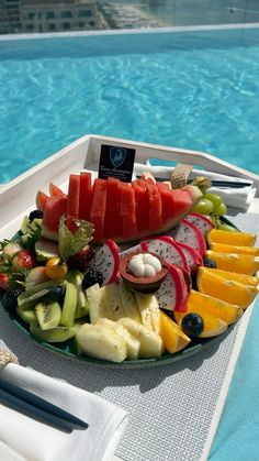 watermelon, melon, radishes and other fruits on a plate by the pool