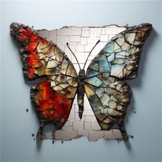 a butterfly made out of broken glass sitting on top of a wall