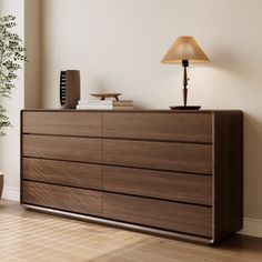 a wooden dresser sitting in the corner of a room next to a lamp and potted plant