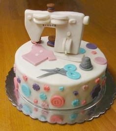 a birthday cake decorated with buttons and sewing equipment on top of a wooden table that says happy birthday gidget