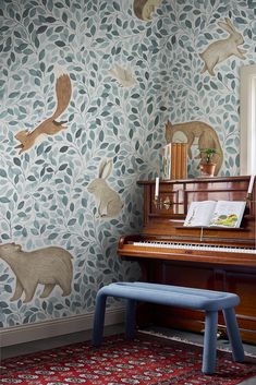 a piano in front of a wall with animals on it